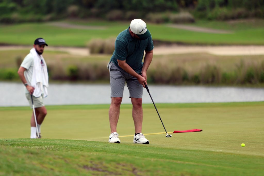 Ty Rucarean (right), a former golfer for the University of Florida, attempts a putt during a U.S. Open qualifier with his caddie -- and brother -- Tyler watching at The Conservatory at Hammock Beach in Palm Coast, Fla., 
